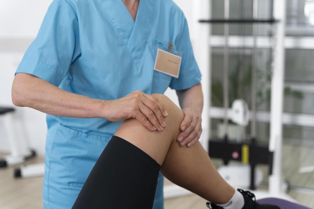 Physiotherapist supporting a patient during hip and knee rehabilitation
