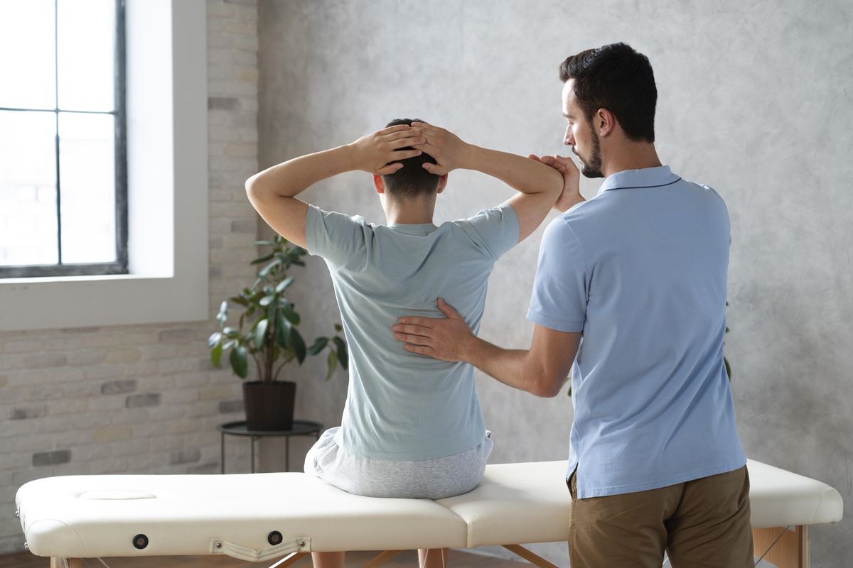 Physiotherapist checking a patient's back